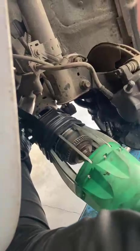 Mecánico de Quickway trabajando en el tren delantero de un auto elevado